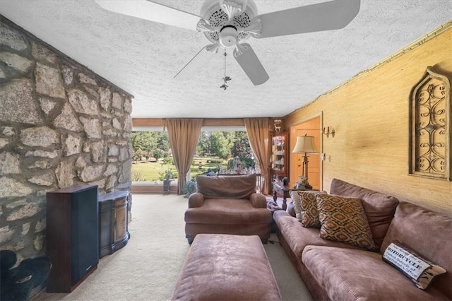 living room featuring ceiling fan, a textured ceiling, and carpet