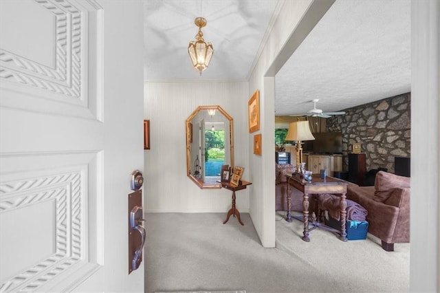 entryway with carpet floors, ornamental molding, and ceiling fan