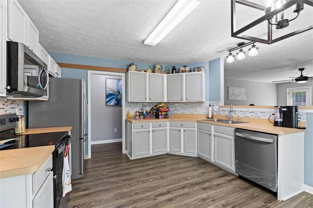 220 Brookstone Trl, Braselton, GA 30517 - kitchen with appliances with stainless steel finishes, a textured ceiling, light countertops, tasteful backsplash, and dark wood-style floors