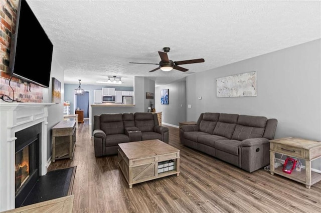 220 Brookstone Trl, Braselton, GA 30517 - living area with wood finished floors, a glass covered fireplace, ceiling fan, and a textured ceiling