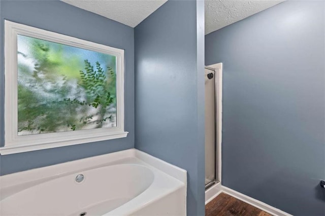 220 Brookstone Trl, Braselton, GA 30517 - full bathroom with a bath, a shower stall, wood finished floors, and a textured ceiling