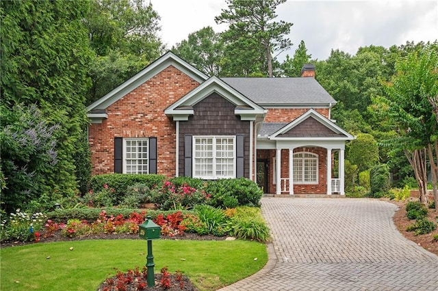 1006 Arbor Trce NE, Atlanta, GA 30319 - view of front facade featuring brick siding, a chimney, a front yard, and driveway
