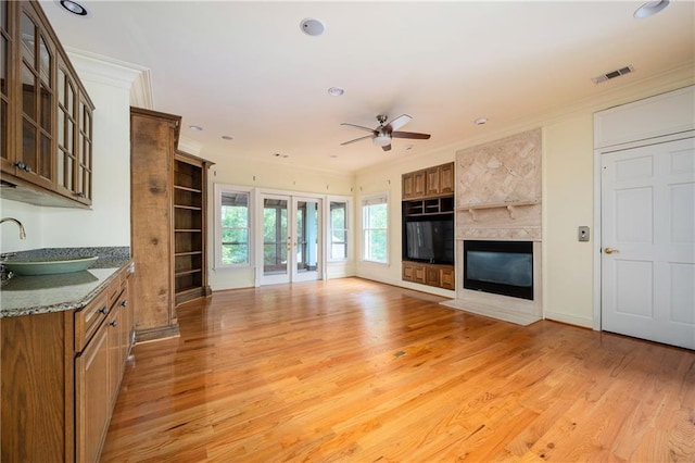 1006 Arbor Trce NE, Atlanta, GA 30319 - unfurnished living room with a ceiling fan, light wood-type flooring, crown molding, a fireplace with flush hearth, and recessed lighting