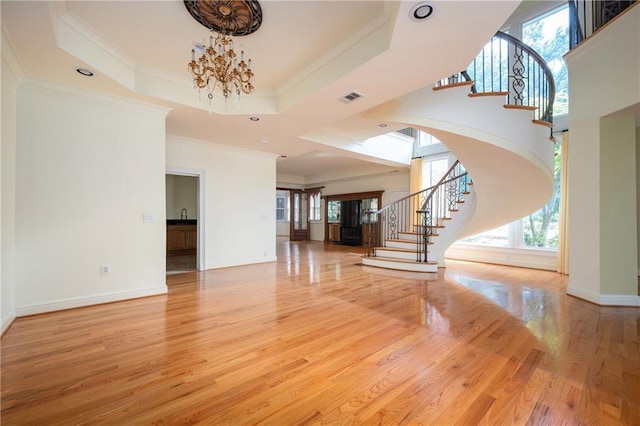 1006 Arbor Trce NE, Atlanta, GA 30319 - entryway with stairs, a chandelier, light wood-style flooring, ornamental molding, and a raised ceiling