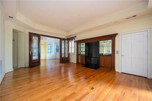 1006 Arbor Trce NE, Atlanta, GA 30319 - unfurnished living room featuring crown molding, light wood-style floors, a tray ceiling, and a fireplace