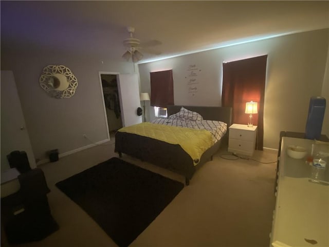 carpeted bedroom featuring baseboards and a ceiling fan