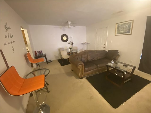 living room with carpet, a ceiling fan, and baseboards