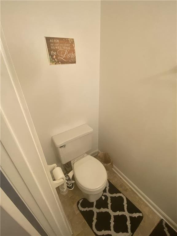 bathroom with baseboards and toilet