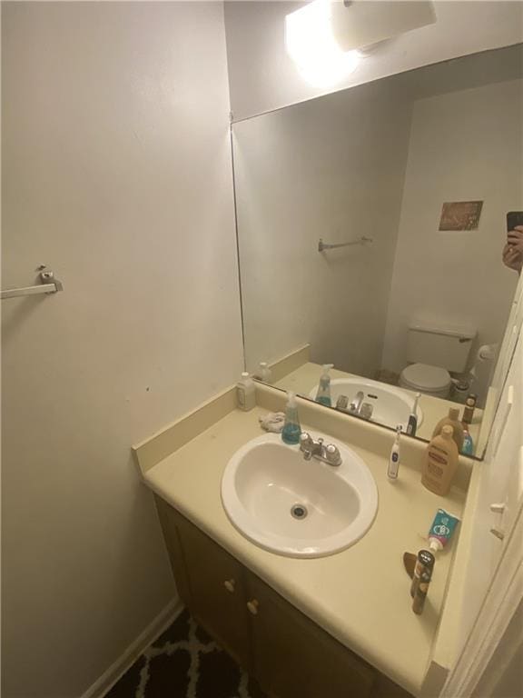 bathroom featuring vanity, toilet, and baseboards