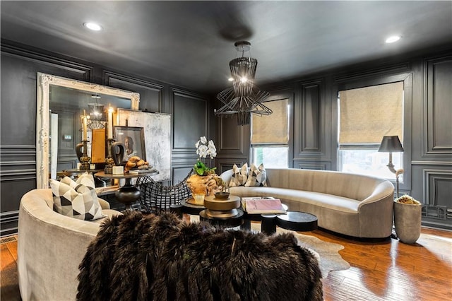 living room with a notable chandelier, recessed lighting, hardwood / wood-style flooring, and a decorative wall