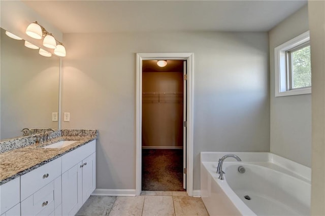 4421 Fulson Dr, Lilburn, GA 30047 - bathroom featuring vanity, a garden tub, tile patterned flooring, a spacious closet, and baseboards