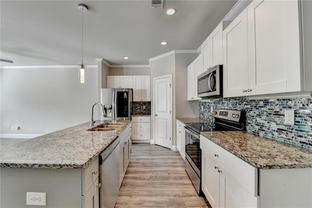 4421 Fulson Dr, Lilburn, GA 30047 - kitchen featuring appliances with stainless steel finishes, a sink, ornamental molding, backsplash, and light wood-style flooring