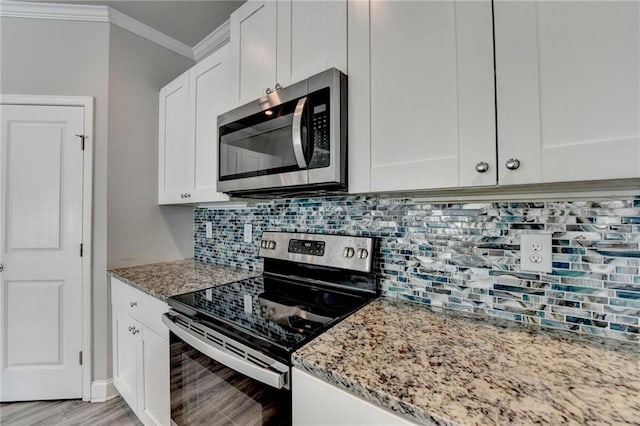 4421 Fulson Dr, Lilburn, GA 30047 - kitchen featuring appliances with stainless steel finishes, ornamental molding, white cabinetry, and light stone counters