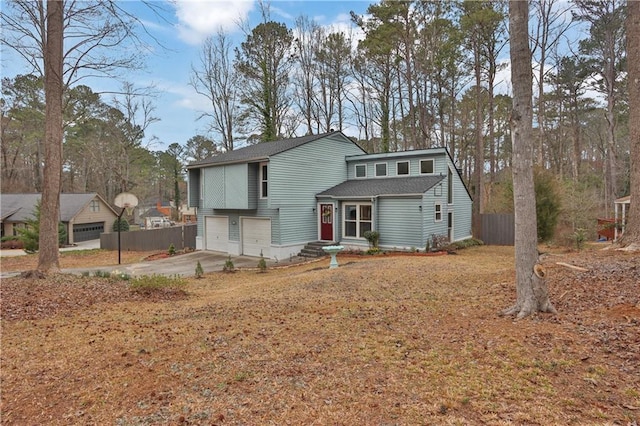 view of front of home with a garage, driveway, and fence