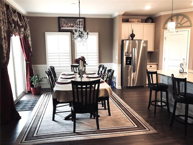 dining space with a notable chandelier, a wainscoted wall, crown molding, and dark wood-style floors