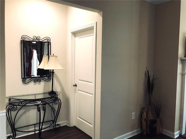 hallway featuring baseboards and dark wood-style flooring