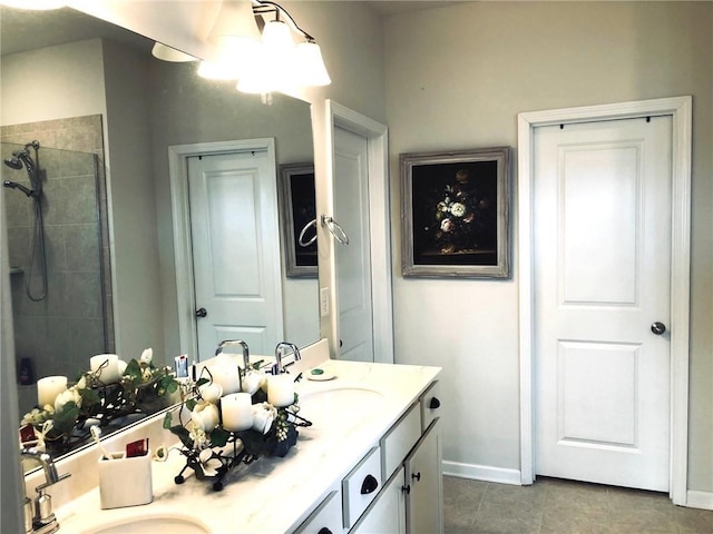 bathroom with double vanity, a tile shower, and a sink