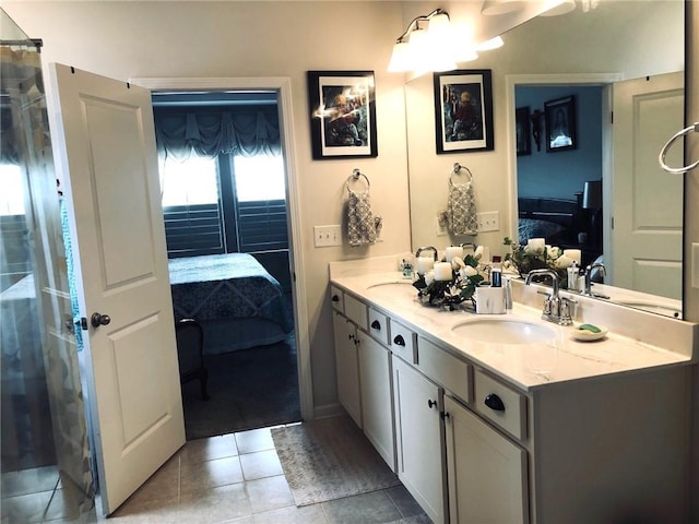 ensuite bathroom featuring double vanity, tile patterned flooring, connected bathroom, and a sink