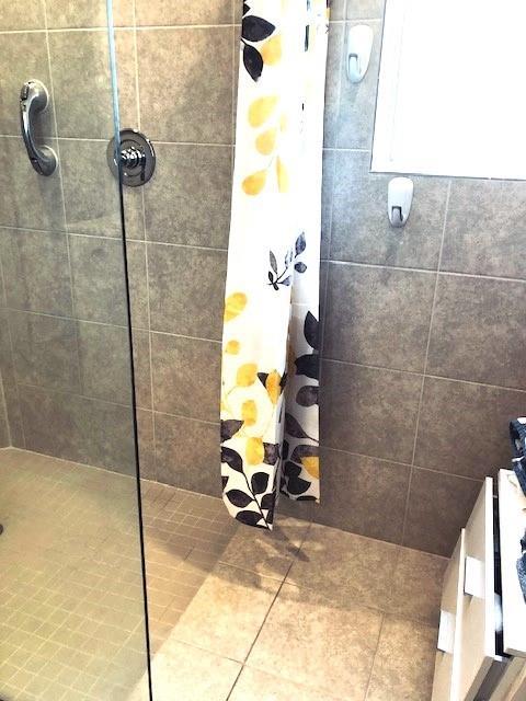 full bathroom with tile patterned flooring and tiled shower