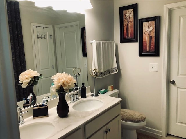 full bathroom featuring double vanity, toilet, and a sink