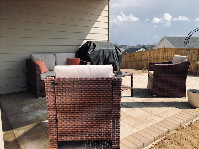 view of patio featuring an outdoor living space, grilling area, and fence