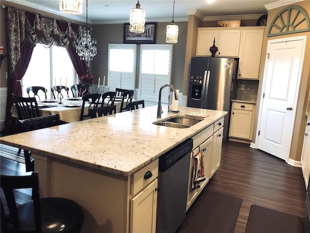 kitchen with crown molding, pendant lighting, an island with sink, stainless steel dishwasher, and a sink