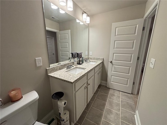 bathroom featuring tile patterned flooring, toilet, visible vents, and a sink