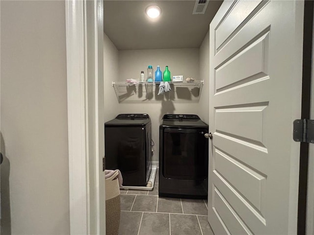 laundry room featuring tile patterned flooring, laundry area, visible vents, and separate washer and dryer