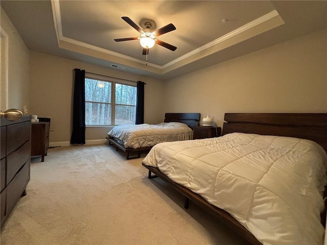 bedroom featuring baseboards, visible vents, ornamental molding, light carpet, and a raised ceiling