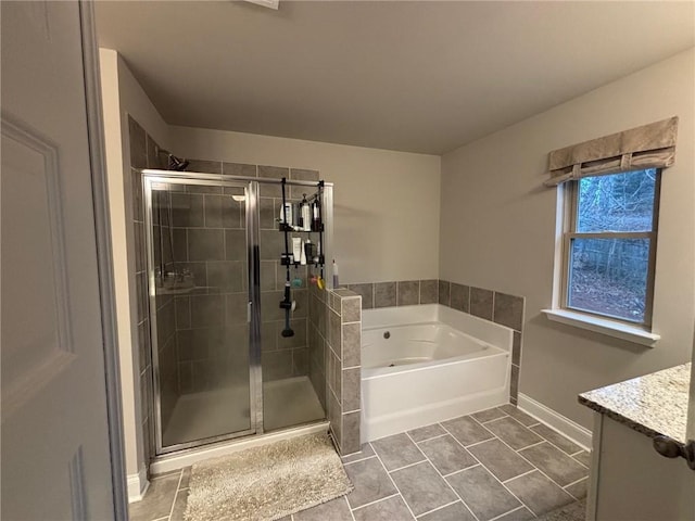 bathroom featuring vanity, baseboards, a stall shower, a garden tub, and tile patterned floors