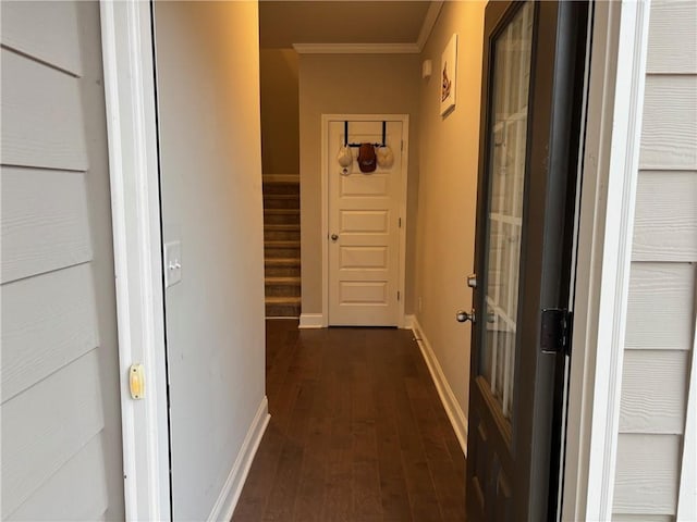 hallway featuring stairway, baseboards, crown molding, and dark wood-type flooring