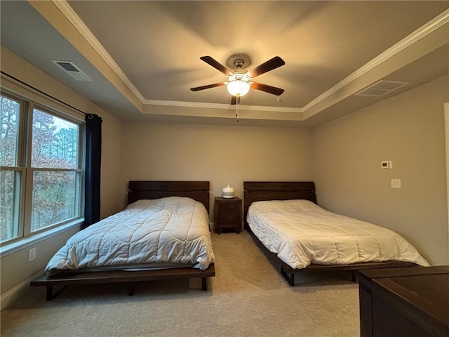 carpeted bedroom featuring visible vents, crown molding, and a raised ceiling