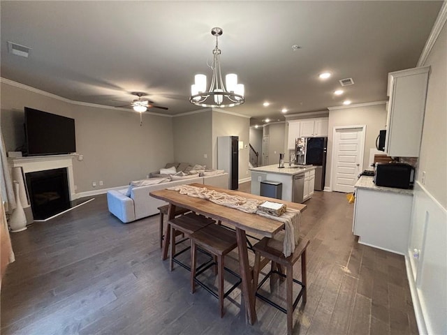 dining room featuring visible vents, ornamental molding, and ceiling fan with notable chandelier