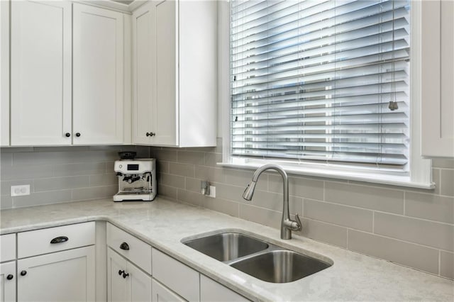 kitchen featuring white cabinets, tasteful backsplash, and sink