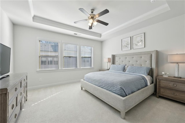 carpeted bedroom with ceiling fan and a tray ceiling