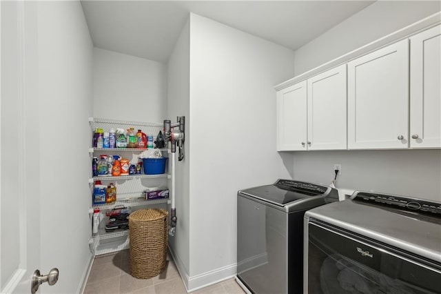 laundry room featuring separate washer and dryer, cabinets, and light tile patterned flooring