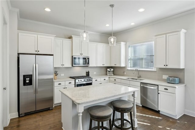 kitchen with a center island, hanging light fixtures, stainless steel appliances, white cabinetry, and sink