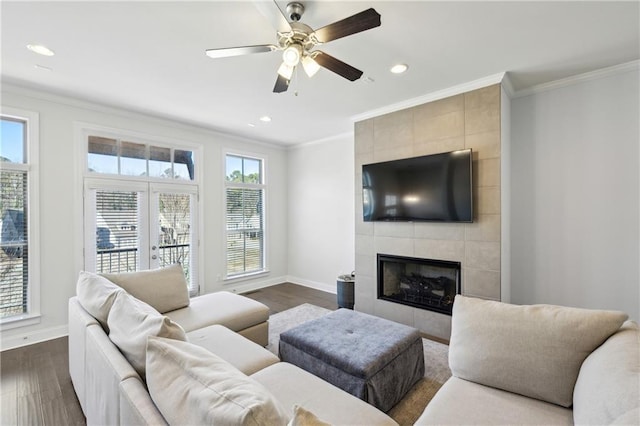 living room with dark hardwood / wood-style flooring, a fireplace, ceiling fan, and crown molding