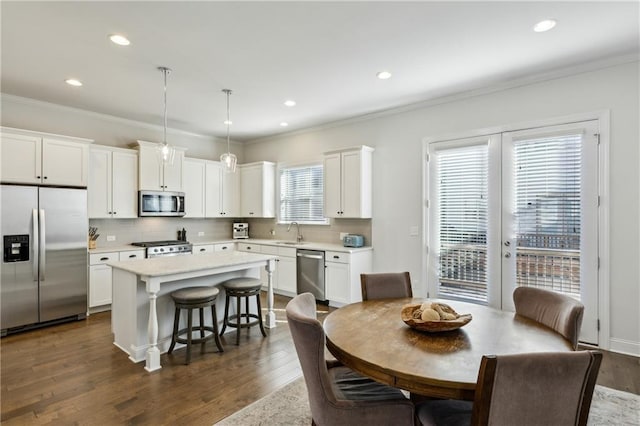 dining space with plenty of natural light, ornamental molding, dark hardwood / wood-style flooring, and sink