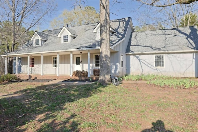 new england style home with board and batten siding, a porch, and a front yard