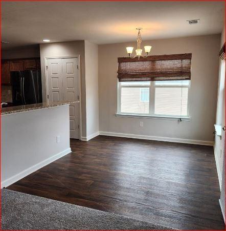 interior space featuring dark hardwood / wood-style floors and an inviting chandelier