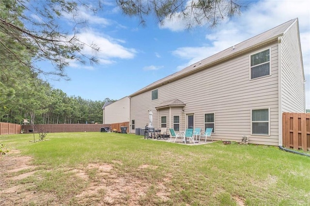 rear view of property with a fenced backyard and a patio area