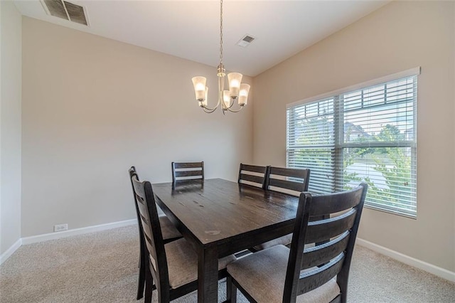 dining room featuring healthy amount of natural light, a chandelier, carpet floors, and lofted ceiling