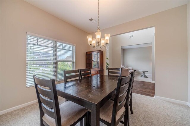 dining space featuring a chandelier and light colored carpet