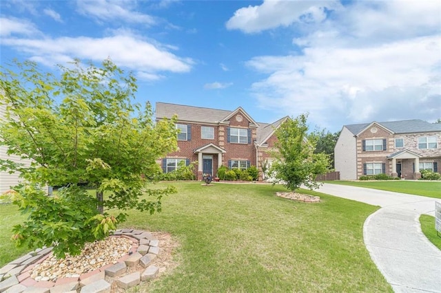 view of front of house featuring a front lawn and brick siding