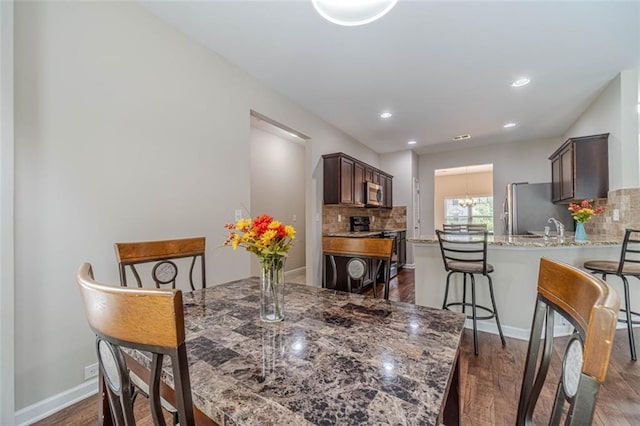 dining area with dark wood-style floors and recessed lighting