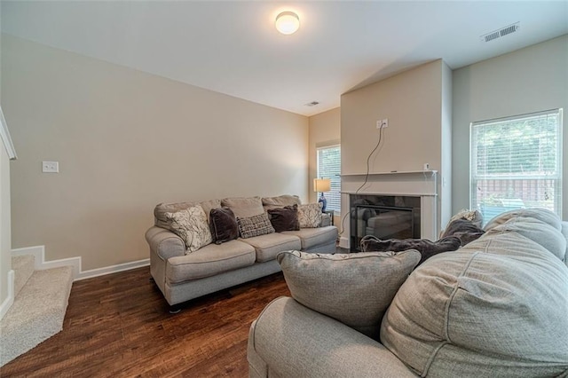 living room featuring dark wood-style floors and a glass covered fireplace