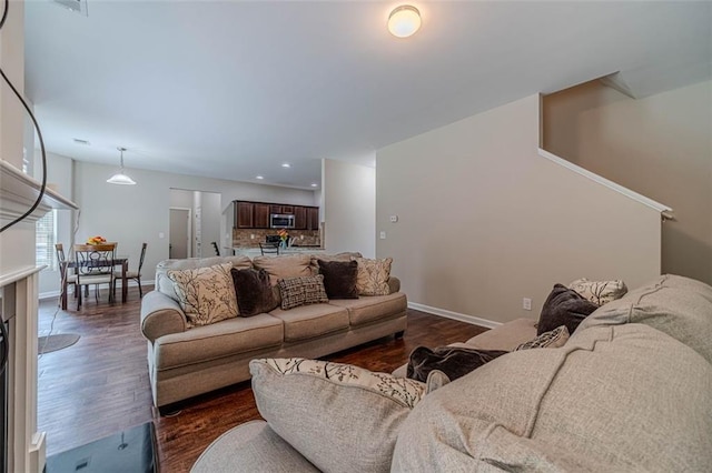 living room with dark wood-type flooring and recessed lighting