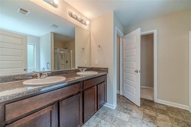 full bathroom with double vanity and a shower stall
