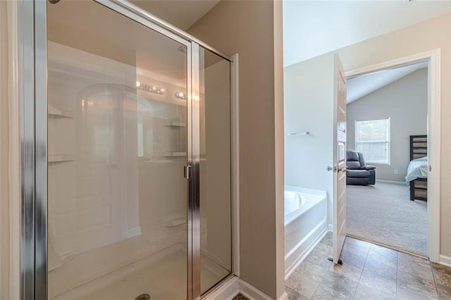 ensuite bathroom featuring a shower stall, a garden tub, and vaulted ceiling